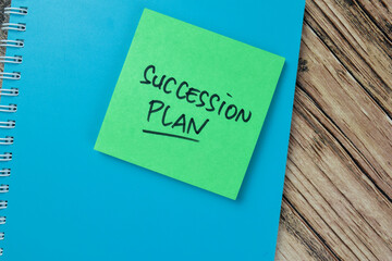 Concept of Succession Plan write on sticky notes isolated on Wooden Table.