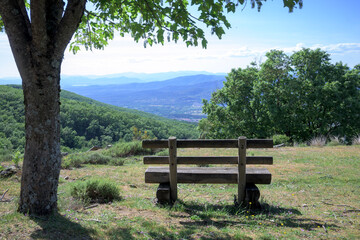 Wooden bench in a mountain area to observe the landscape and nature and meditate