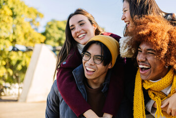 Young group of multiracial friends having fun together on winter vacation. Millennial people enjoying day off in the city. Friendship and holidays concept. - obrazy, fototapety, plakaty