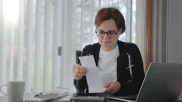 Woman sit at workplace desk feels frustrated concerned due high taxes, loan debt, dismissal, staff cuts notice