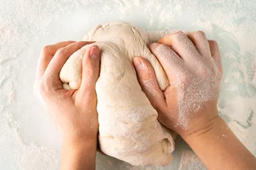 Foto auf Acrylglas hands in flour crumple the dough for pizza or pies, the process of cooking bakery products © Надежда Урюпина