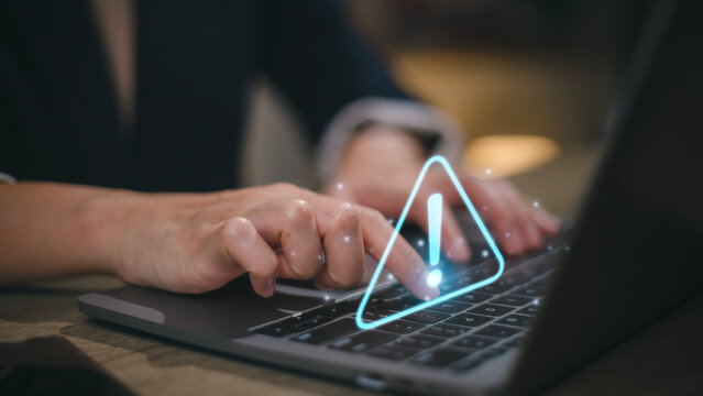 Businesswomen using computer laptop or tablet with triangle caution warning sign for notification error and maintenance concept.