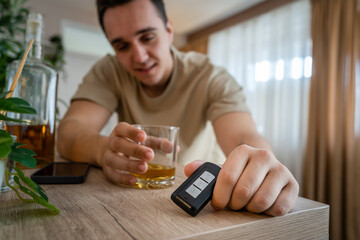 one man sit at home with bottle of liquor drink whiskey drunk alcoholic Alcohol abuse, addiction and man depression concept drink and drive copy space hold car keys