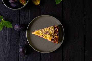 Piece of plum pie on a dark background