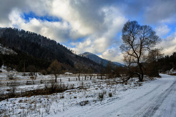 Winter mountains and road, cloudy sky. Carpathians