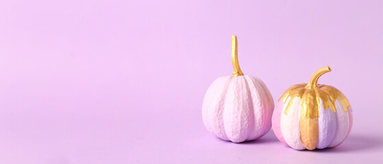 Beautifully painted pumpkins on lilac background with space for text