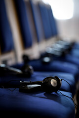 Multiple language translation wireless headphones on blue elegant chairs before conference