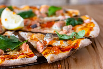 Delicious hot pizza with salmon, red caviar, tomatoes and aragula ready to eat. banner, menu, recipe place for text, top view.