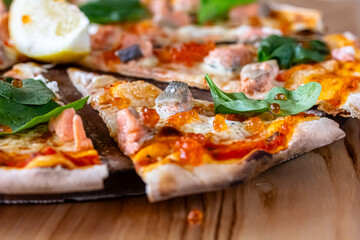 Delicious hot pizza with salmon, red caviar, tomatoes and aragula ready to eat. banner, menu, recipe place for text, top view.