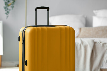 Yellow suitcase in light bedroom