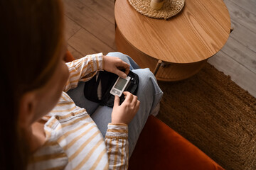 Woman with diabetes measuring blood sugar level at home