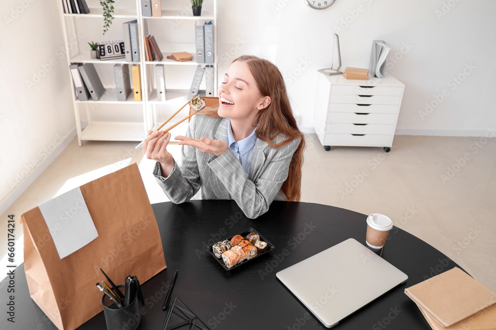 Canvas Prints Happy young woman eating sushi in office