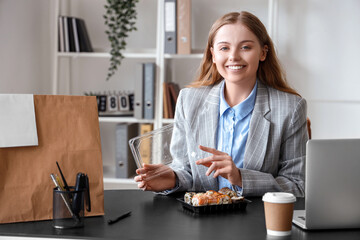 Happy young woman with sushi and paper bag in office