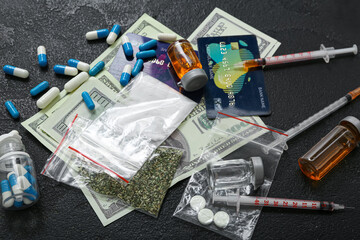 Different drugs, syringes, money and credit cards on dark background - obrazy, fototapety, plakaty