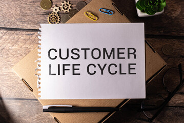 CUSTOMER LIFE CYCLE text on a blue background with keyboard and clipboard, business concept