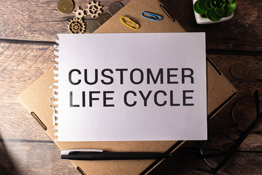CUSTOMER LIFE CYCLE text on a blue background with keyboard and clipboard, business concept