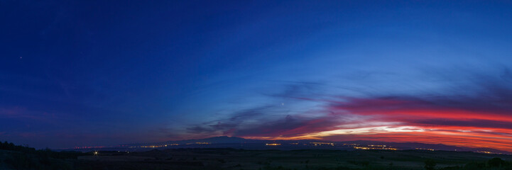 Panorama of evening twilight after sunset with planets Venus, Jupiter and Saturn colorful sky over mountain landscape, Arguedas, Navarra, Spain