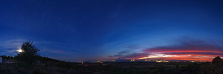 Panorama of evening twilight with colorful sky and Moon, Jupiter, Saturn and Venus over mountain...