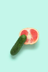 Fresh cucumber and grapefruit on turquoise background. Sex education concept