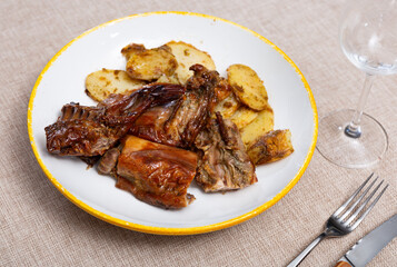 Baked juicy and crispy rabbit pieces served with spicy roasted potatoes