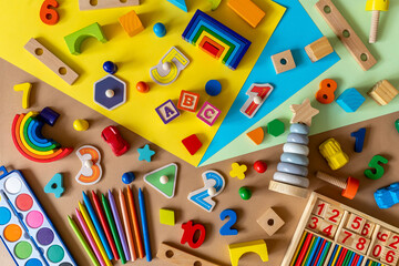 Wooden kids toys on colourful paper. Educational toys blocks, pencils. Toys for kindergarten, preschool or daycare. Back to school. Copy space for text.	