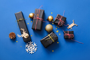 Black Christmas gift boxes and beautiful decorations on blue background