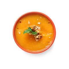 Bowl of delicious pumpkin cream soup with walnut and parsley on white background