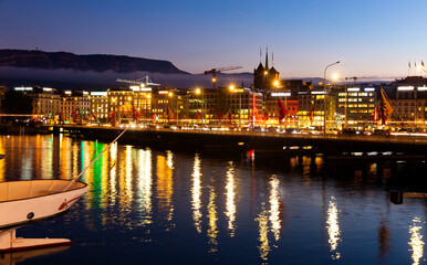 Fototapeta premium Photo of embankment in Geneva during evening with turned on city lights.