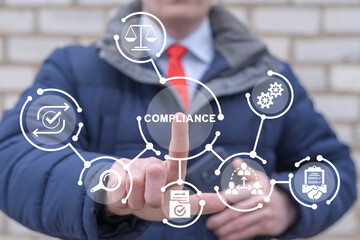 Businessman using virtual touch screen presses word: COMPLIANCE. Corporate regulatory and...