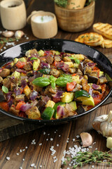 Delicious ratatouille in baking dish served on wooden table, closeup