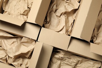 Open cardboard boxes with crumpled paper, top view. Packaging goods