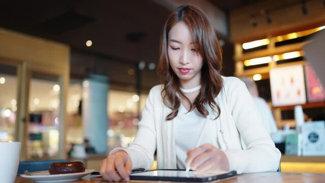 portrait of a beautiful Asian women watch digital class e-learning online for employee reskill upskill on notebook computer 
at home office workplace. Business school lesson education for adult people