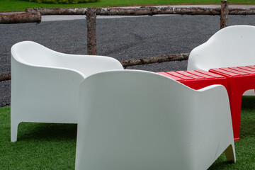 Three large white weather resistant chaise loungers made of plastic, are stackable furniture, next...