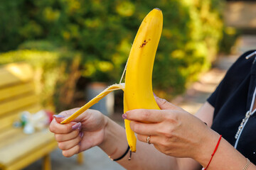 Woman's hand holding bananas, snack and fast food concept. Selective focus on hands with blurred...