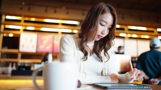 portrait of a beautiful Asian women watch digital class e-learning online for employee reskill upskill on notebook computer 
at home office workplace. Business school lesson education for adult people