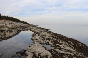 Beach and rocks in autumn. Riverside with stones. Reflect of water and river. Horizon and peaceful...