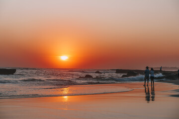 sunset in the Canggu beach,silhouette of unrecognizable couple
