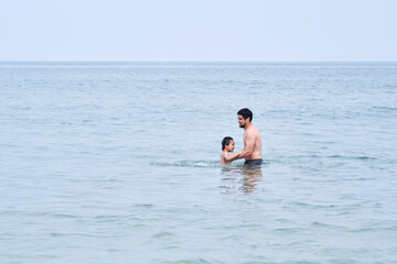 Dad plays with his sons in the sea.