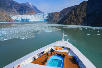 Bow of a cruise ship facing the South Sawyer Glacier at the end of Tracy Arm Fjord in southeast Alaska, USA - Coastal glacier in the Pacific Ocean - obrazy, fototapety, plakaty
