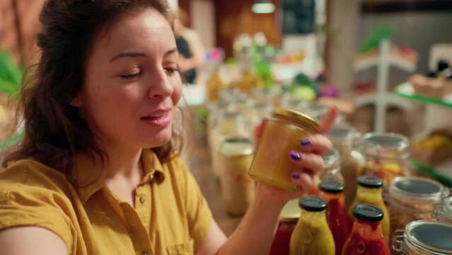 Woman films vlog praising hidden gem sustainable local neighborhood supermarket, impressed by high quality natural products. Health influencer shows around newly opened zero waste shop