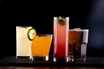 various colorful cocktails prepared on black background with lemonade gin tonic strawberry orange vat vodka