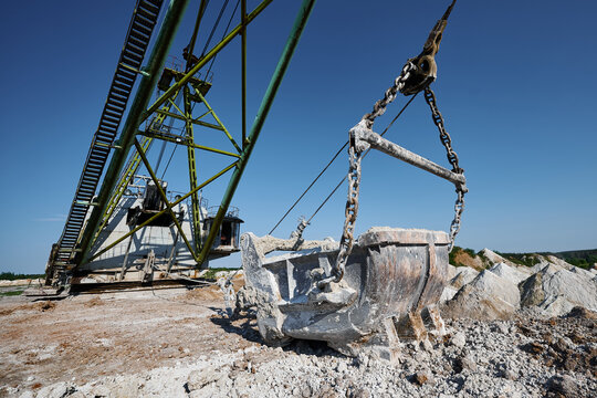 Empty bucket of modern dragline on ground at chalk quarry