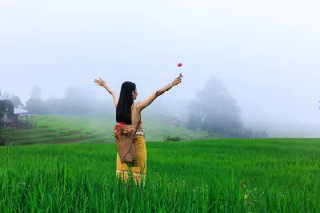 Gordijnen young girl tourist and flower basket back stand holding hand  and happy smiling morning mist at rice terrace, in the rain season Ban Pa Bong Piang, Chiang Mai Thailand © SHUTTER DIN