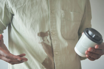  men hands with spilled coffee over his shirt