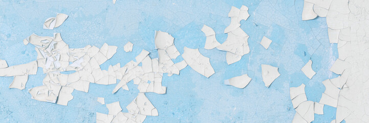 Peeling paint on the wall. Old concrete wall with cracked flaking paint. Weathered rough painted surface with patterns of cracks and peeling. High resolution texture for background and design. Closeup