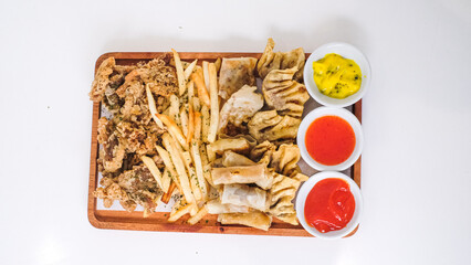 Nusantara Platter: A Flavorful Feast of French Fries, Crispy Fried Chicken Skin, Fried Mushroom, and Bakso Tahu Special with Delicious Condiment Sauces
