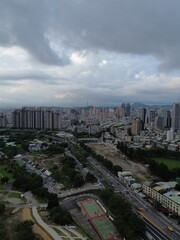Naklejka na ściany i meble Aerial view of Taipei City by drone with large modern buildings and skyscrapers. River passing through the city with Taipei 101 in the background. Residential buildings with parks.