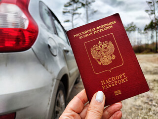 Russian passport in hand of woman. Russian cars banned for entering in Europe. Russian tourism...