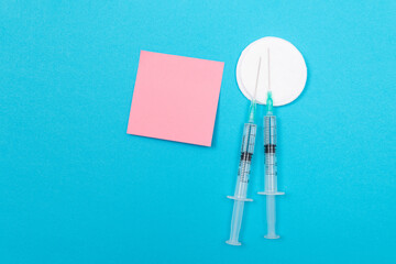 Vaccination, Immunology or Revaccination Concept - Two Medical Disposable Syringe Lying on Blue...