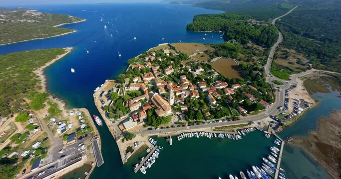 High angle aerial overview of Osor, cinematic FPV drone swoops down onto city